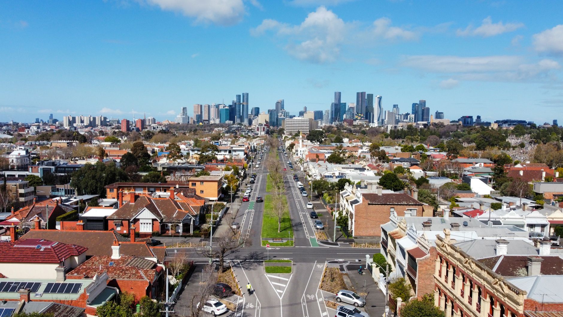 Aerial view over rooftops looking towards a city skyline