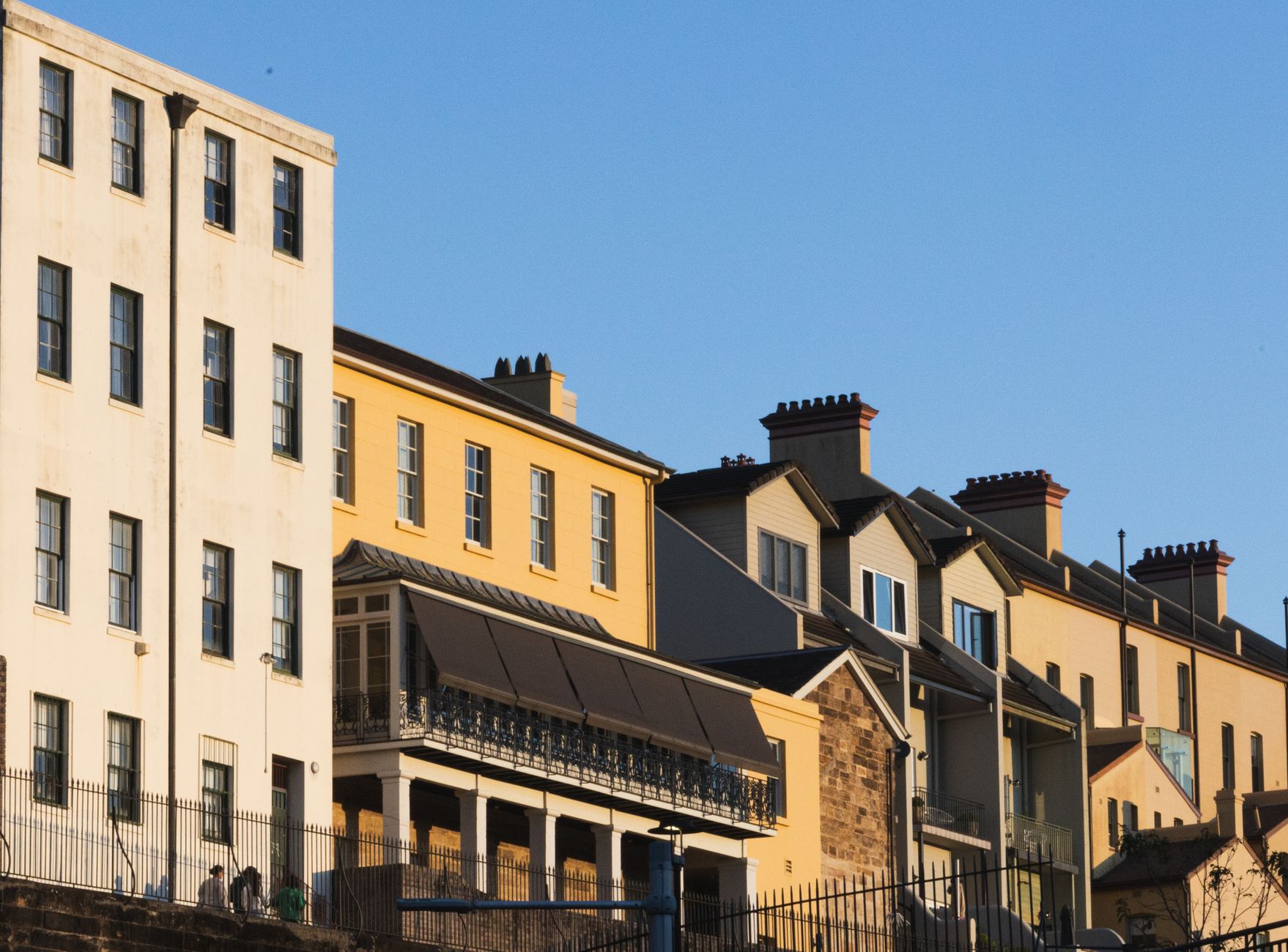 Golden afternoon light on a row of heritage terrace houses with iron lace balconies