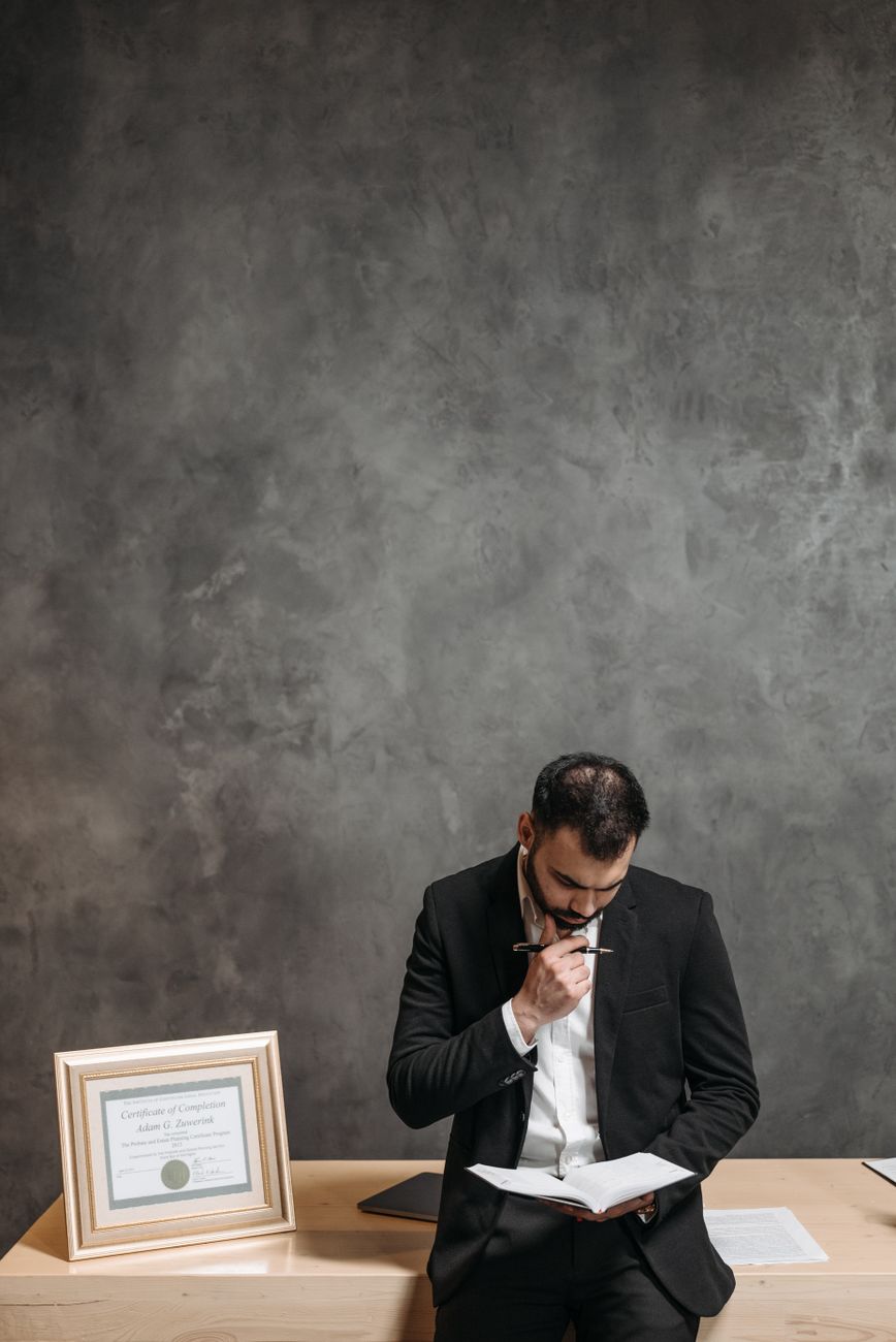 Principal reading case notes at his desk