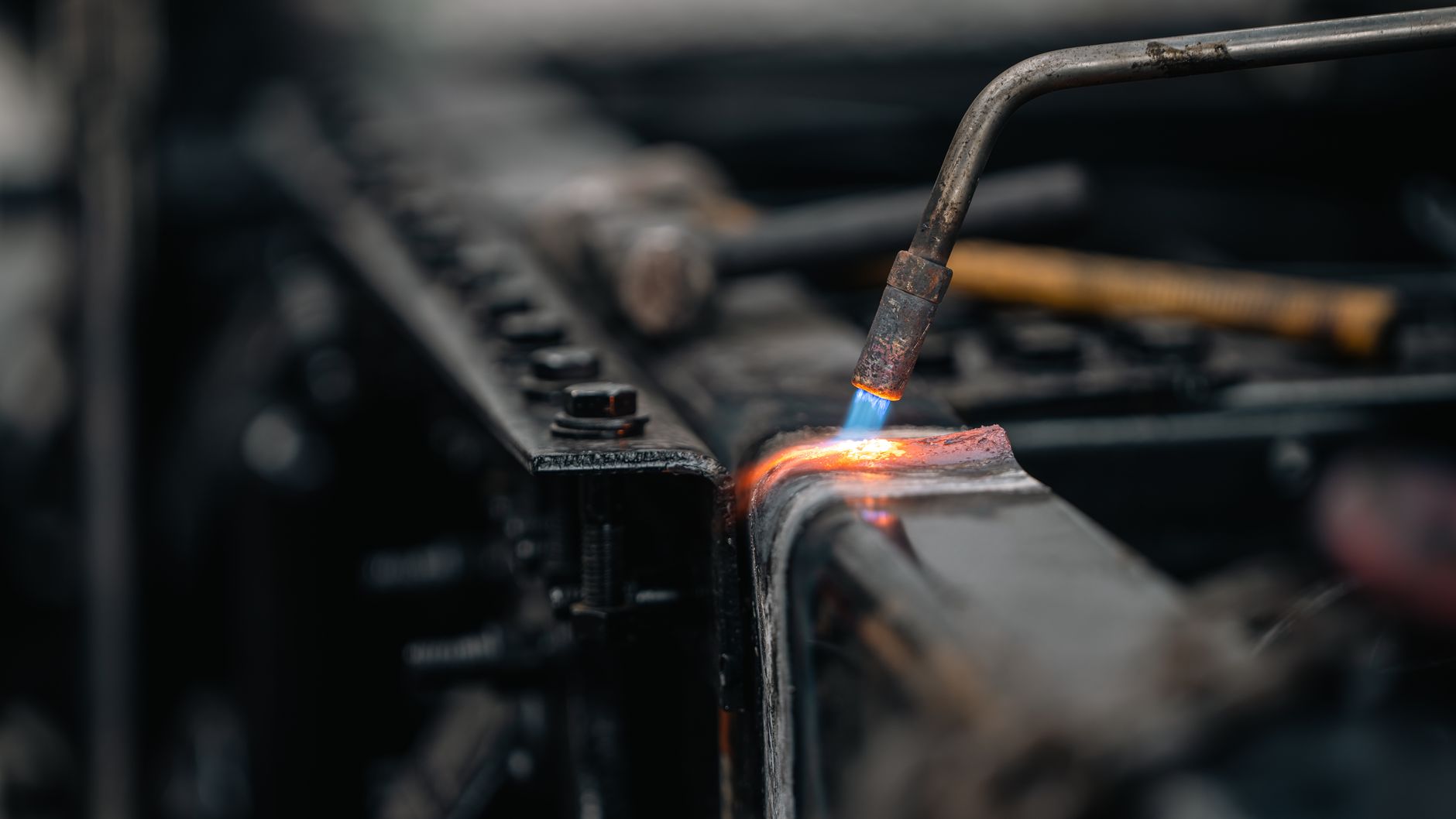 Blue flame of a brazing torch heating a metal joint
