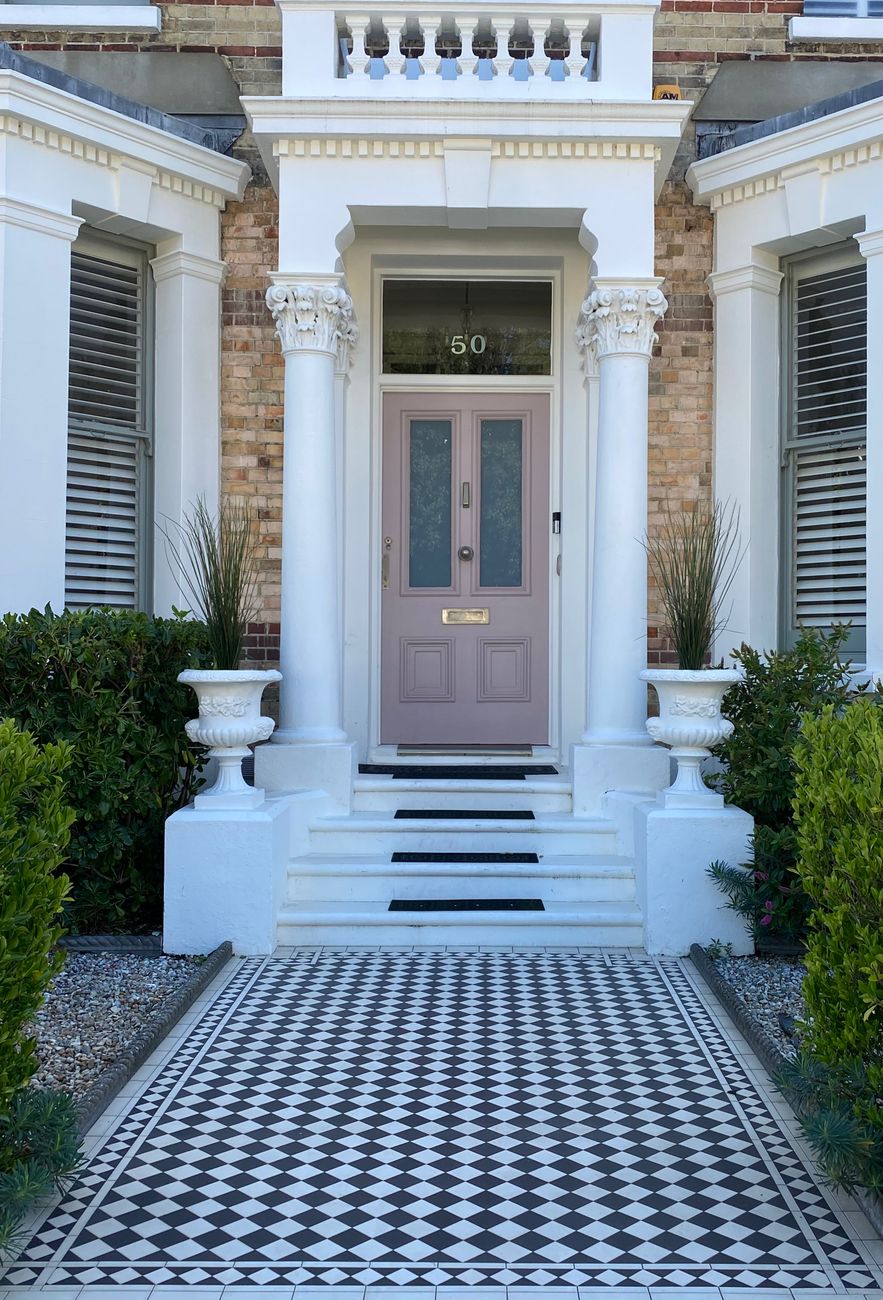 A Victorian terrace entrance with a columned portico and tessellated tiled path